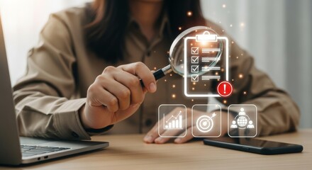 Woman analyzing data with magnifying glass and laptop on desk  