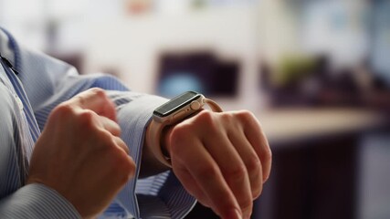 Smart watch using in office, Successful asian businessman use smartwatch at workplace, man chooses apps and smile happy with apps, employee inside office use laptop at work. - Powered by Adobe