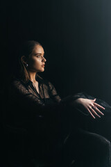 A mysterious woman stands in silhouette against a bright window, surrounded by dramatic smoke and shadows