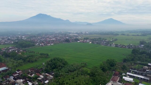 Aerial view of a beautiful mosque with Mount Kawi and Mount Arjuno in the background, Malang Regency, Indonesia