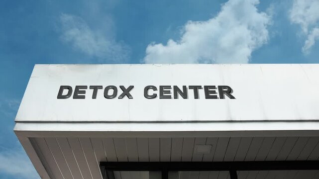 Detox Center word sign displayed on building facade with clear blue sky, highlighting a modern health facility dedicated to addiction recovery, rehabilitation, and wellness