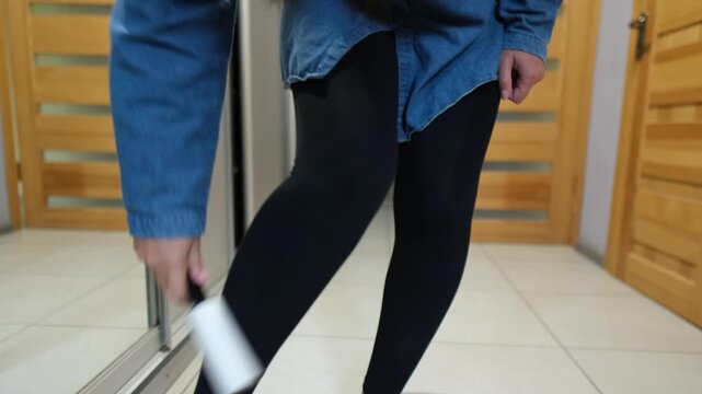 Cleaning black leggings with lint roller at home, everyday clothing care