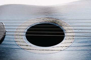 Acoustic guitar with hole in middle. Closeup strings.