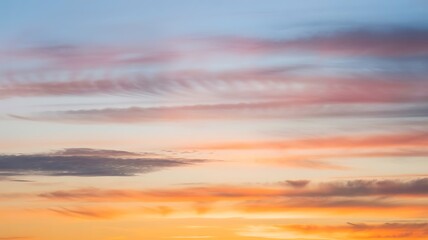 Fototapeta premium Sunset Sky With Wispy Pink and Orange Clouds Across a Blue Sky stock photo