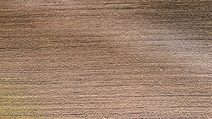 Close-up view of textured earth surface with distinct patterns created by farming equipment, showcasing the rich brown soil in an agricultural field.