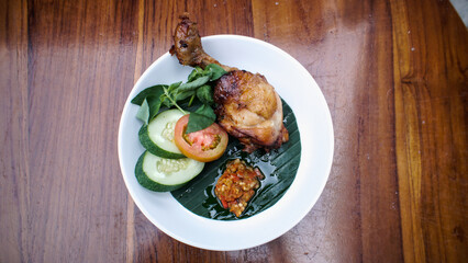 Overhead shot of fried chicken with vegetables and chili paste on a plate.