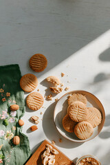 A cozy, relaxed tabletop scene with a plate of homemade shortbread cookies seen from above. cozy home baking, slow living, comfort food, rustic kitchen aesthetics