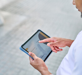 Portrait of a young  businessman wman using a tablet computer  in a city park, surrounded by modern corporate office buildings architecture