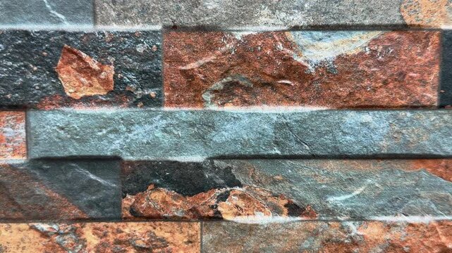 Continuous movement in the foreground of a slate cladding in shades of brown, gray, and black