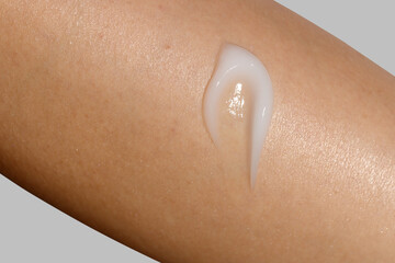 Fototapeta premium Close-up of skincare cream smear on womans skin. Cosmetic skincare product texture. Face cream, body lotion swipe swatch