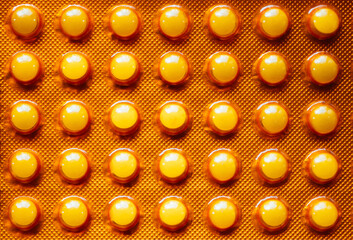 Orange blister pack of pills macro clean background