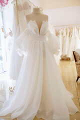 Elegant wedding gown displayed on a mannequin in a showroom ambiance