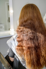 Portrait of beautiful young woman with long red hair isolated on white background