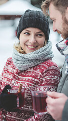 happy young Couple in love cuddling at the Christmas market and drink mulled wine