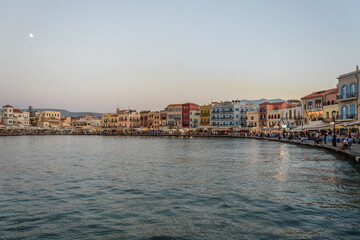 Fototapeta premium Chania Old Town Waterfront at Dusk with Vibrant Cafés and Shops, Crete, Greece