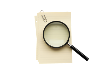 A magnifying glass is placed on a stack of papers with a paperclip on a white background.