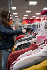 Young woman browsing clothes on a rack