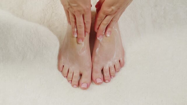 Woman using cream cosmetics in bathroom, applying moisturizing cream to her leg while sitting in a bathtub. Skincare and body care routine, middle aged woman use scrub macro close up. 