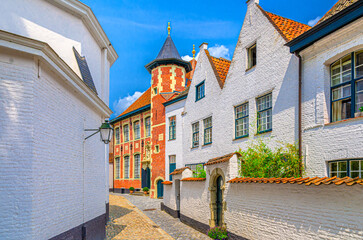 Beguinage Courtrai of Saint-Elisabeth, Begijnhof van Kortrijk with white houses and Sint-Annazaal museum on narrow paving stone street in Kortrijk city historical centre, Flemish Region, Belgium