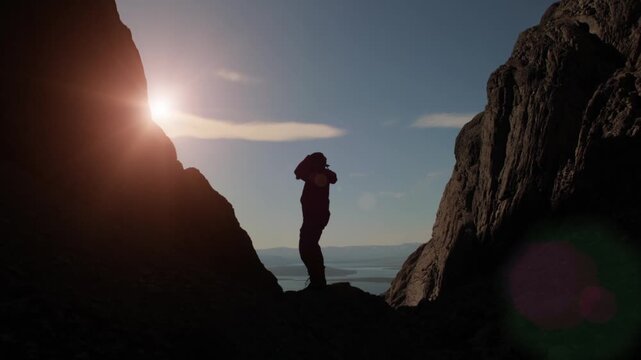 A guy is dancing a fun dance in the mountains.  Success and luck