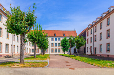 Lycee Bartholdi College building and courtyard with alley green trees in old town Colmar city historic centre, Alsace Grand Est region, France