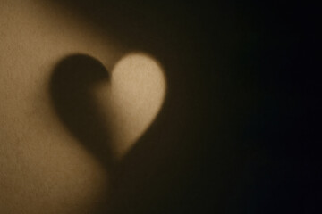 A heart-shaped shadow on the wall is a symbol of love. Space for text.