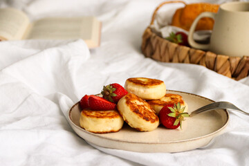 Cozy breakfast with coffee, croissant and fresh strawberries on a wicker tray in natural morning light. Minimalistic home lifestyle concept.