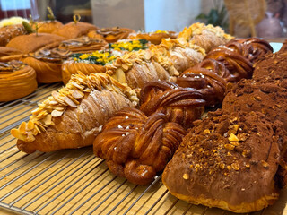 Assortment of croissants and twisted pastries in bakery showcase. Sweet and nutty flavors