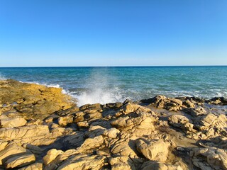 coastal landscape scene, serene rocky seascape view, vast turquoise sea with rocky foreground