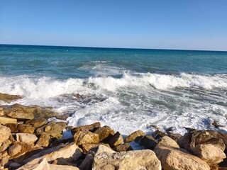 energetic waves exploding on rocky shoreline for dramatic adventure and surf advertising visuals