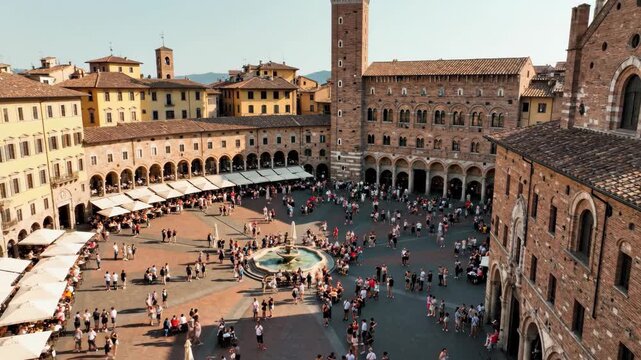 Aerial view of busy piazza del campo with crowds and fountain under clear sky in siena
