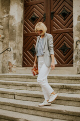 Woman in casual outfit walking down stone steps outdoors © BGStock72