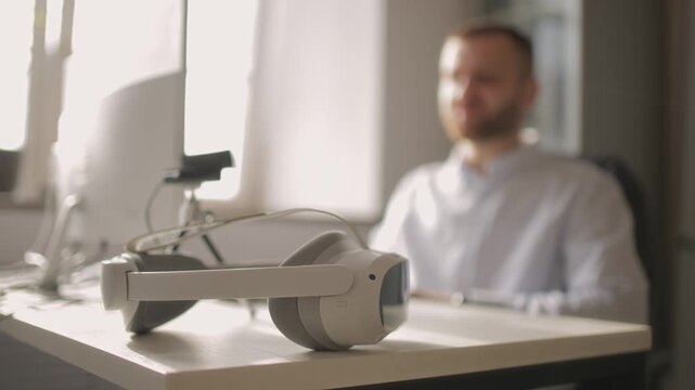 Caucasian young male businessman using computer with virtual reality headset on desk for video call.