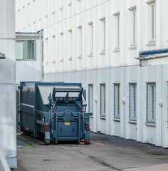 Large industrial waste container behind office building.