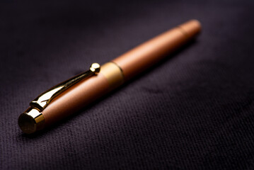 Fototapeta premium Fountain pen, beautiful details of a fountain pen on a black surface, low key photo, selective focus.