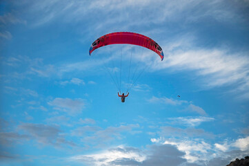 Oludeniz, Turkey. A close-up of a paraglider's red parachute  against a cloudy sky.
