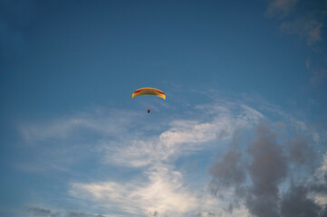 Oludeniz, Turkey. A yellow paraglider against a cloudy sky in the evening.