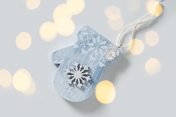 Xmas decorative mittens as wooden toy designed with snowflake for Christmas tree. Festive eco natural decor Christmas celebrations and holiday spirit.