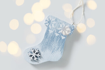 Wooden stocking ornament designed with snowflake patterns. This festive decor piece, painted in shades of blue and white, is ready to enhance Christmas celebrations and holiday spirit.