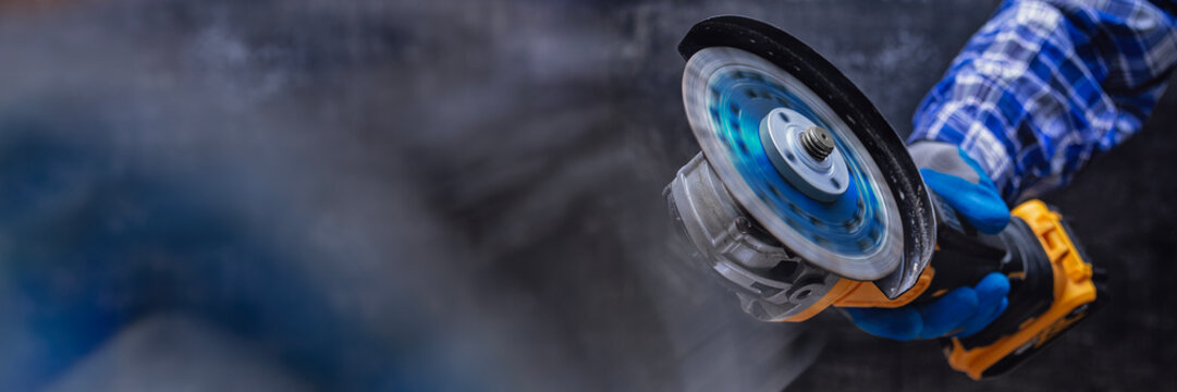 Close-up of a construction worker using an angle grinder with a fast-spinning cutting disc. Concept for professional craftsmanship in construction and renovation work.