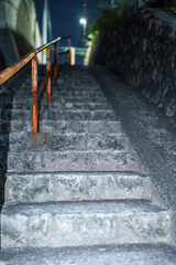 夜の石段と錆びた手すりが導く路地の上り道