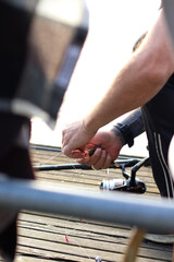 A collection of photos showing a man fishing on a calm lake in summer. The series includes images of fishing gear, bait box, fishing rods, boats, and peaceful water reflections.