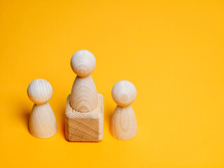 Wooden leader figure on a pedestal representing leadership and hierarchy