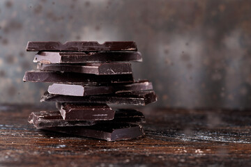 Broken dark chocolate on a wooden table