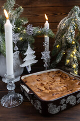 Apple pie in a mold. In the background is a decorated Christmas tree and festive decorations.