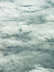 Beautiful aerial view of soft, fluffy clouds creating a serene blanket over the sky during a bright afternoon