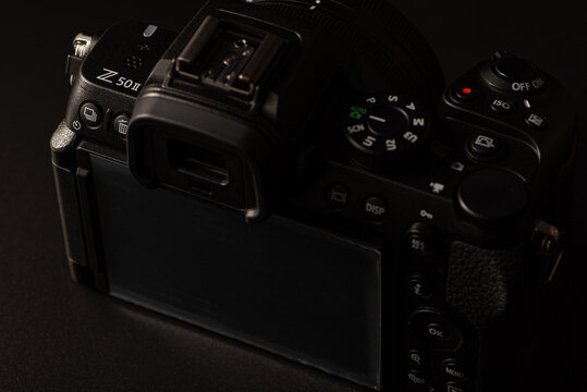 Nikon Z 50ll camera, beautiful details of the Nikon Z 50 ll camera, positioned on a black surface, low key photo, selective focus.