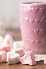 Heart-Shaped Pink and White Marshmallows Scattered near a Pink Cup of Hot Chocolate with Love and Hearts