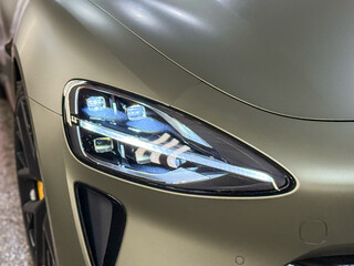 Close up detail on one of the LED headlights modern green car. Exterior closeup detail. Headlights...
