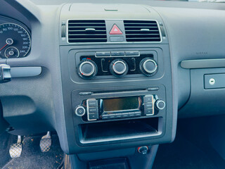 Dashboard view of a car interior showcasing controls and a media system in a modern vehicle parked on a sunny day